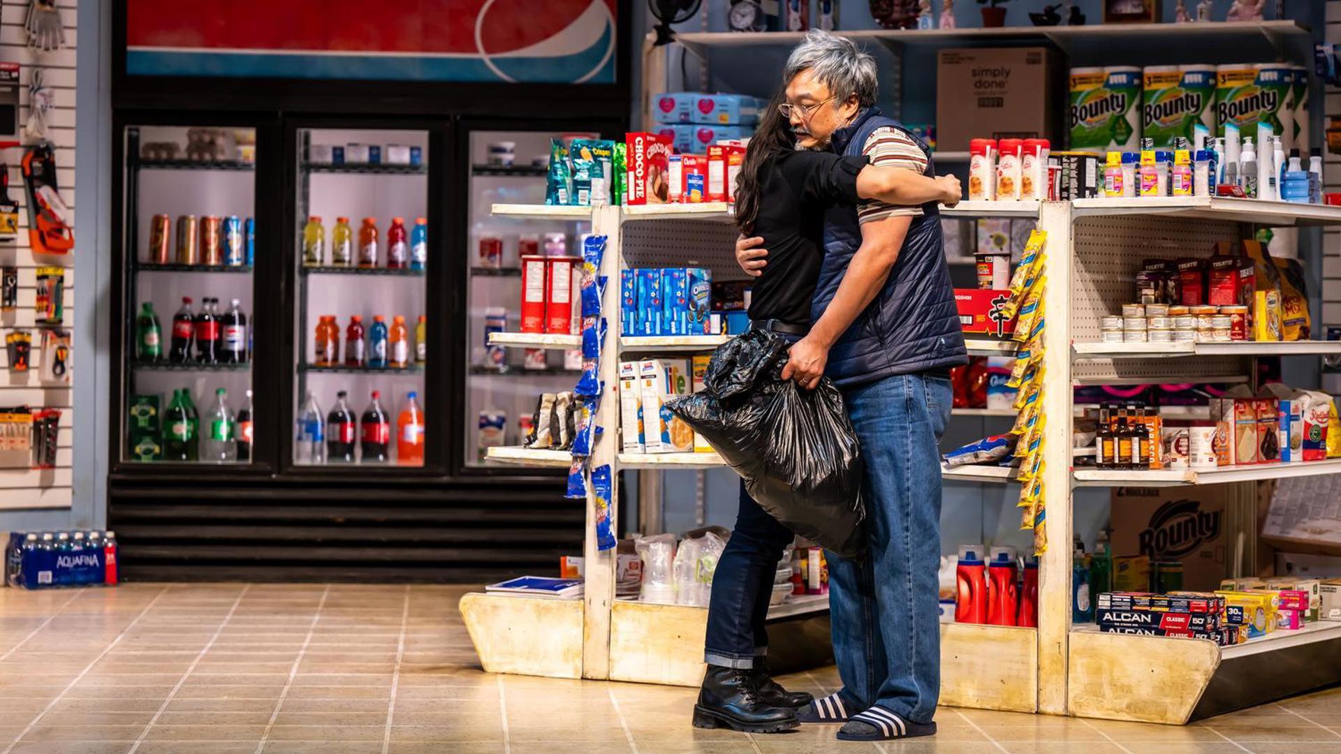 Two people hug inside a convenience store.