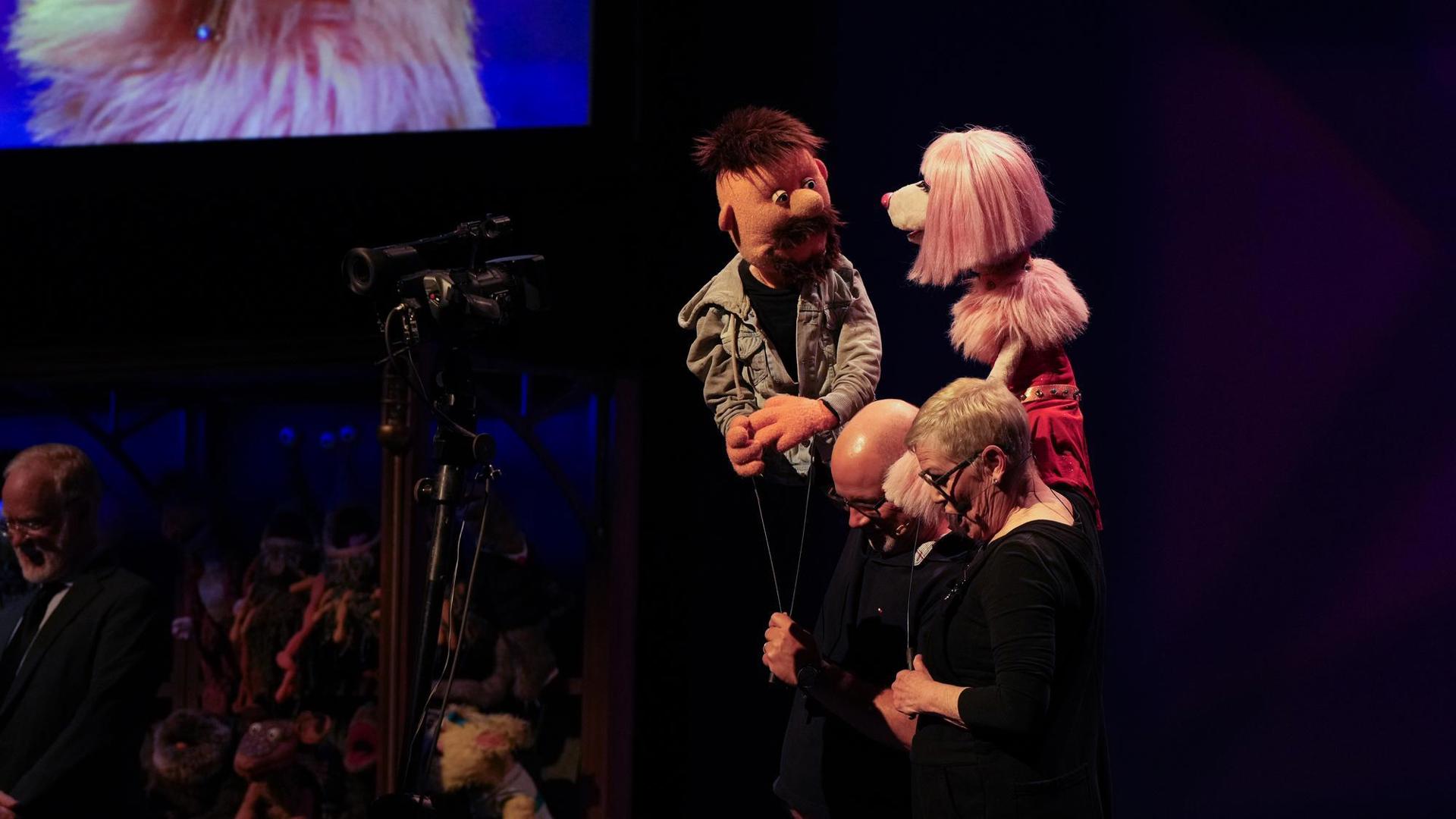 two puppeteers with puppets performing