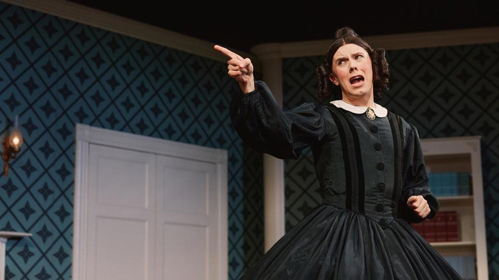 A performer pointing at something off screen.