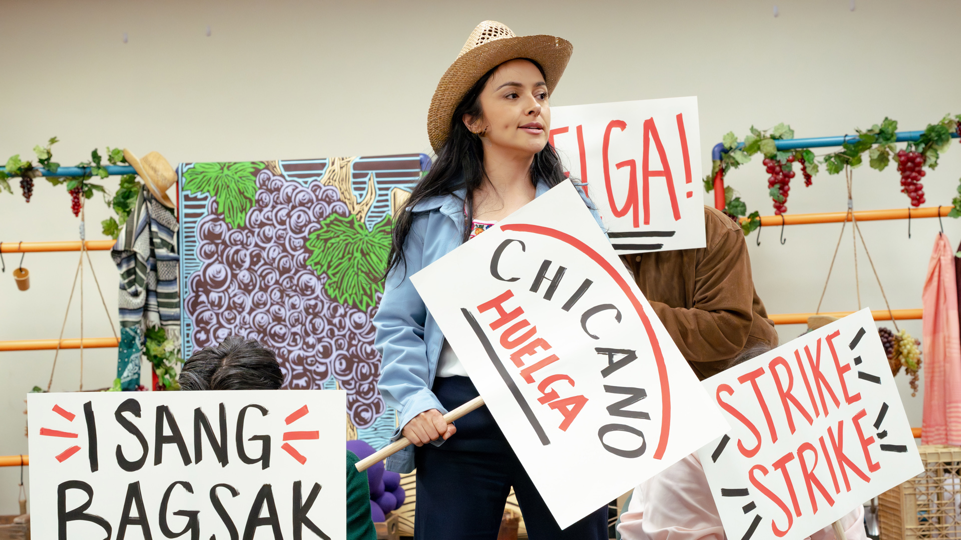People holding protest signs that say "Strike Strike", "I Sang Bagsak", and "Chicano Huelga".